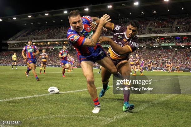 Shaun Kenny-Dowall of the Knights is pushed during the round five NRL match between the Newcastle Knights and the Brisbane Broncos at McDonald Jones...