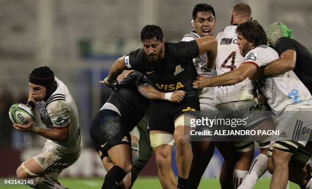 New Zealand's Crusaders flanker Matt Tood runs with the ball past Argentina's Jaguares players during their Super Rugby match at Jose Amalfitani...