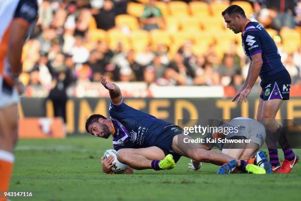 Jesse Bromwich of the Storm is tackled during the round five NRL match between the Wests Tigers and the Melbourne Storm at Mt Smart Stadium on April...
