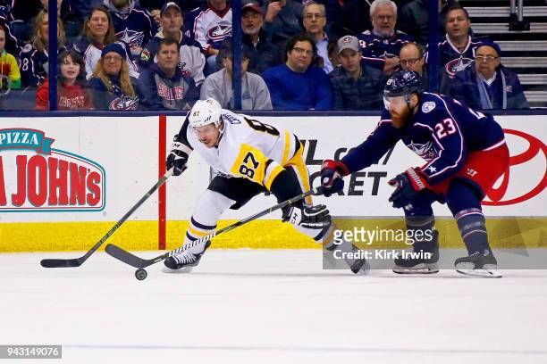 Sidney Crosby of the Pittsburgh Penguins and Ian Cole of the Columbus Blue Jackets battle for control of the puck during the game on April 5, 2018 at...