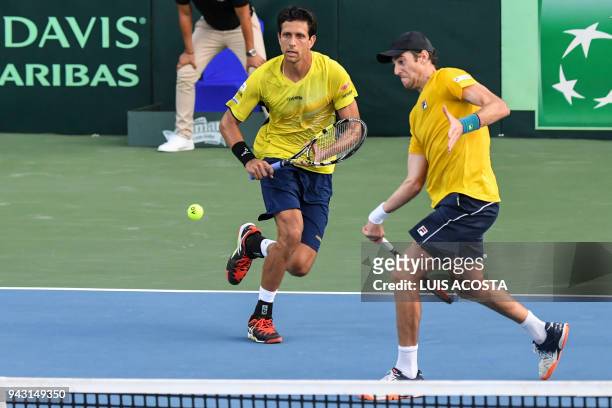 Brazilian tennis player Marcelo Demoliner returns a ball nexto to his teammate Marcelo Melo against Colombian tennis players Juan Sebastian Cabal and...