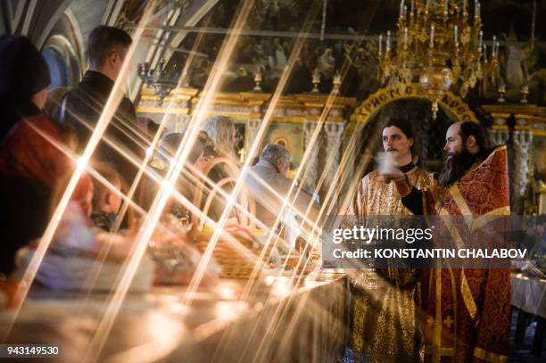 Russian Orthodox priest blesses cakes and colored eggs during an Orthodox Easter ceremony in The Holy Trinity-St.Sergius Lavra in Sergiyev Posad on...