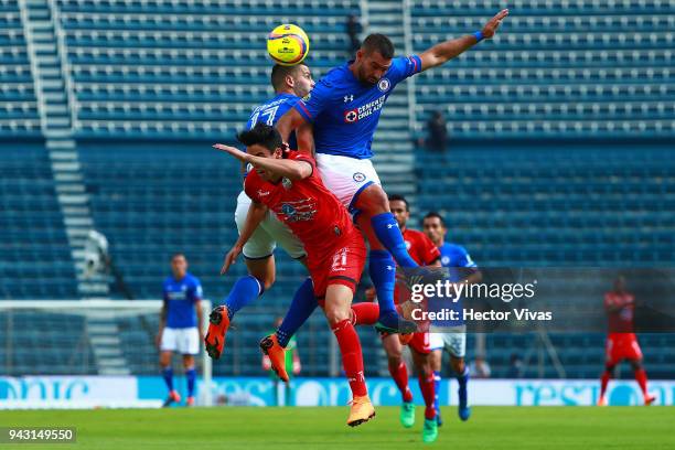 Edgar Mendez and Martin Cauteruccio of Cruz Azul struggles for the ball with Eduardo Tercero of Lobos BUAP during the 14th round match between Cruz...