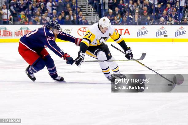 Evgeni Malkin of the Pittsburgh Penguins attempts to keep control of the puck away from Ian Cole of the Columbus Blue Jackets during the game on...