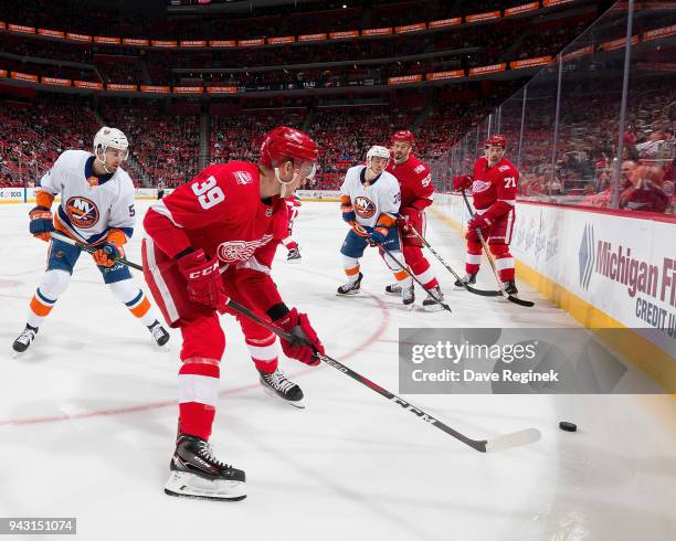 Anthony Mantha, Jonathan Ericsson and Dylan Larkin of the Detroit Red Wings battle in the corner for the puck with Adam Pelech and Anthony...