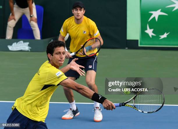 Brazilian tennis player Marcelo Melo returns a ball to Colombian tennis players Juan Sebastian Cabal and Robert Farah as teammate Marcelo Demoliner...