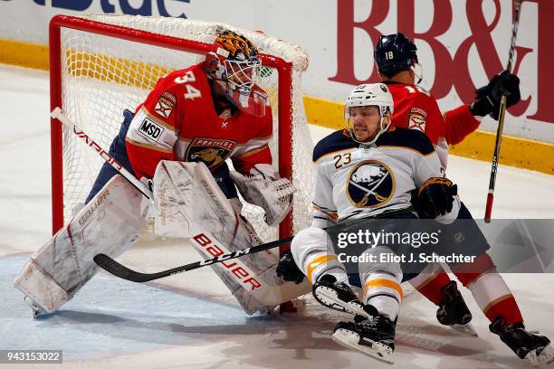Goaltender James Reimer of the Florida Panthers defends the net with the help of teammate Micheal Haley against Sam Reinhart of the Buffalo Sabres at...