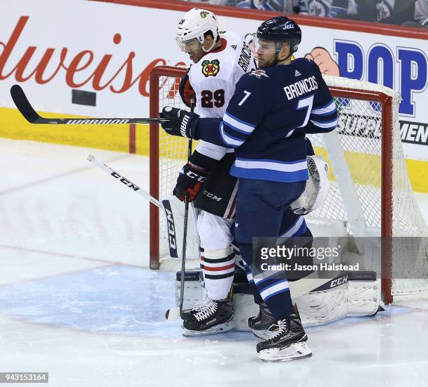 Ben Chiarot of the Winnipeg Jets fends off Andreas Martinsen of the Chicago Blackhawks during NHL action on April 7, 2018 at Bell MTS Place in...
