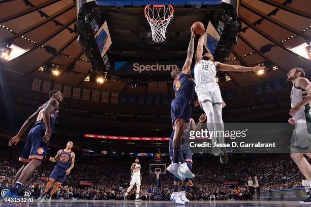 Kyle O'Quinn of the New York Knicks blocks the dunk of Jabari Parker of the Milwaukee Bucks on April 7, 2018 at Madison Square Garden in New York...