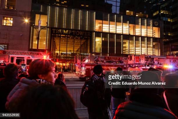 People watch NYPD officers and first responders assess the scene of a fire at Trump Tower on April 7, 2018 in New York City. One person has...
