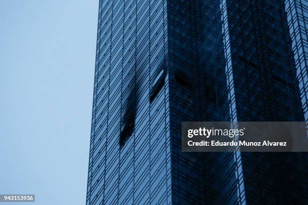 Broken and burned windows are seen after a fire broke out on the 50th floor of Trump Tower on April 7, 2018 in New York City. One person has...