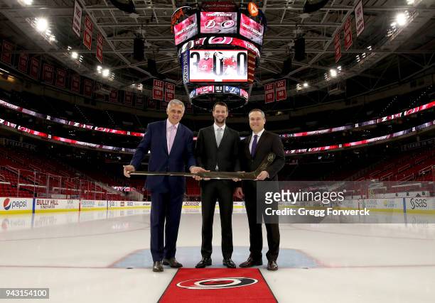 Ron Francis, President of Hockey Operations for the Carolina Hurricanes and Assistant General Manager Brian Tatum present Hurricanes goaltender Cam...