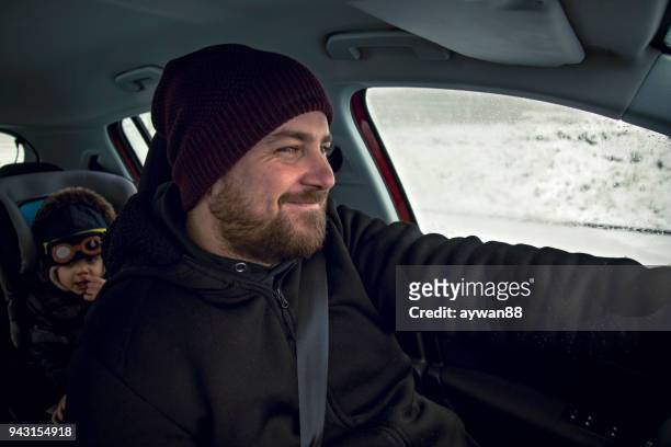 father driving baby son in the car - christmas driving stock pictures, royalty-free photos & images