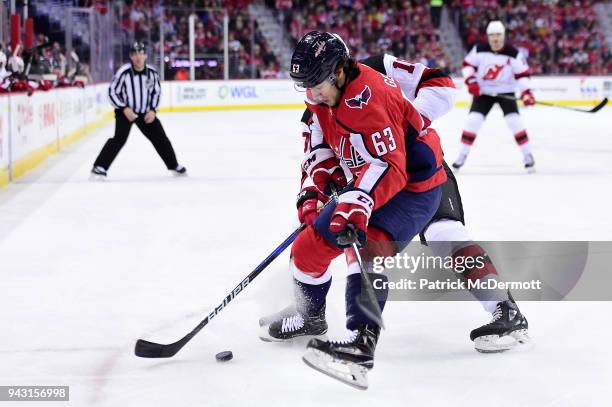 Shane Gersich of the Washington Capitals and Jimmy Hayes of the New Jersey Devils battle for the puck in the first period at Capital One Arena on...