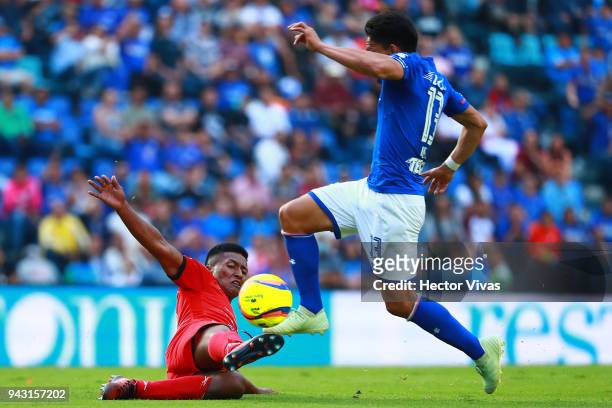 Angel Mena of Cruz Azul jumps over Omar Tejeda of Lobos BUAP during the 14th round match between Cruz Azul and Lobos BUAP at Azul Stadium on April 7,...