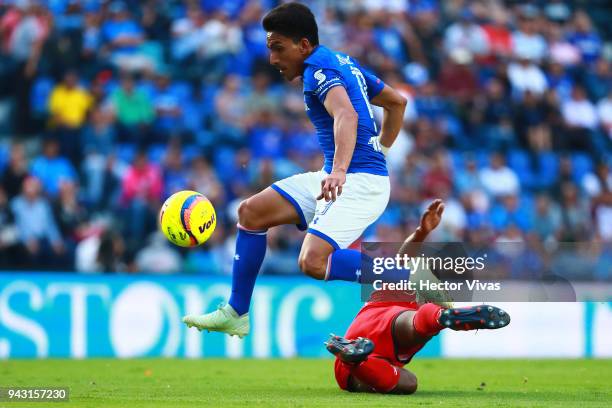 Angel Mena of Cruz Azul jumps over Omar Tejeda of Lobos BUAP during the 14th round match between Cruz Azul and Lobos BUAP at Azul Stadium on April 7,...