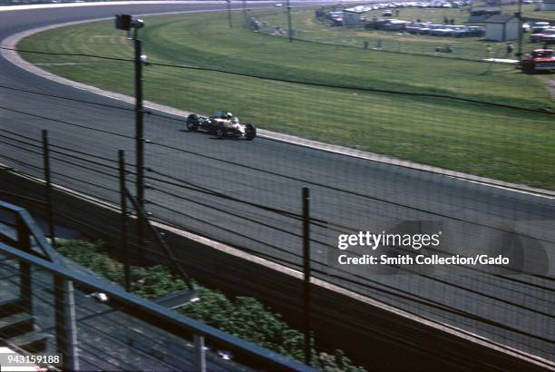 Race cars and spectators are visible at the Indianapolis 500 automobile race at Indianapolis Motor Speedway in Indianapolis, Indiana, 1965.