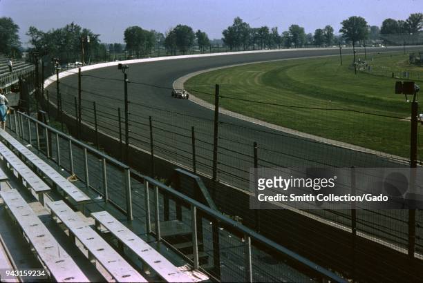 Race cars and empty bleechers are visible at the Indianapolis 500 automobile race at Indianapolis Motor Speedway in Indianapolis, Indiana, 1965.