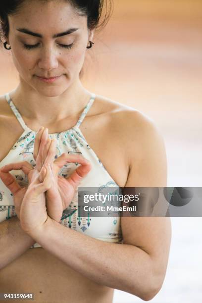 woman practicing yoga meditation. mudra abhaya hridaya position - mudra stock pictures, royalty-free photos & images