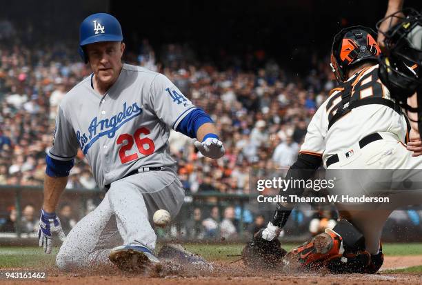 Chase Utley of the Los Angeles Dodgers scores ahead of the throw to Buster Posey of the San Francisco Giants in the top of the third inning of a...