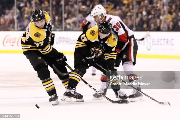 Colin White of the Ottawa Senators defends Patrice Bergeron of the Boston Bruins and Torey Krug during the second period at TD Garden on April 7,...