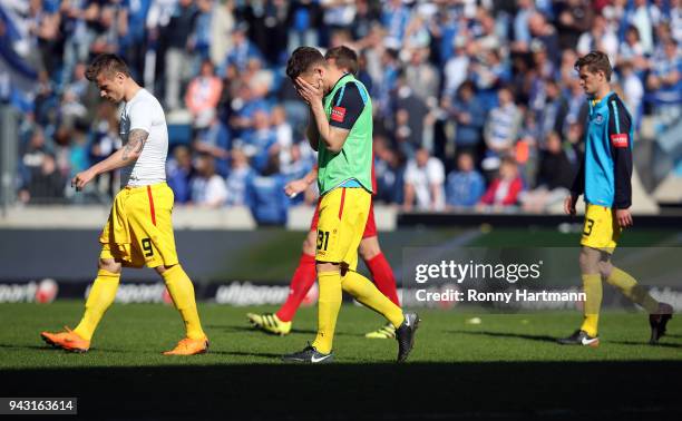 Marvin Pourie, Giuseppe Leo and Kai Buelow of Karlsruher SC leave the pitch after the 3. Liga match between 1. FC Magdeburg and Karlsruher SC at...