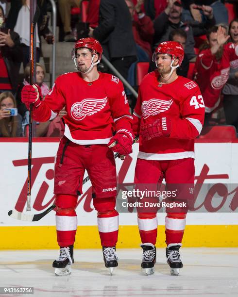 Dylan Larkin of the Detroit Red Wings celebrates his third period goal with teammate Darren Helm during an NHL game against the New York Islanders at...
