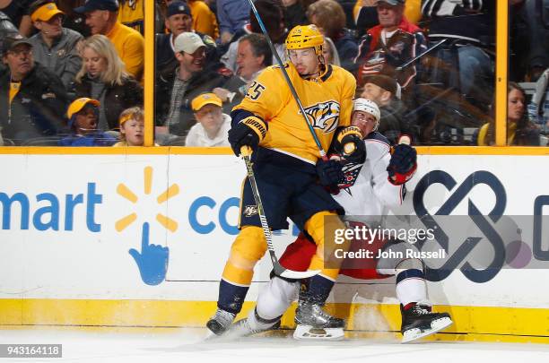 Alexei Emelin of the Nashville Predators checks Brandon Dubinsky of the Columbus Blue Jackets during an NHL game at Bridgestone Arena on April 7,...