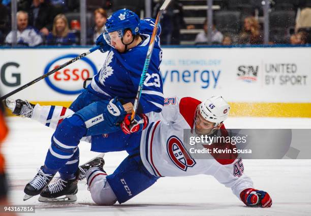 Travis Dermott of the Toronto Maple Leafs gets tangled up with Kerby Rychel of the Montreal Canadiens during the second period at the Air Canada...