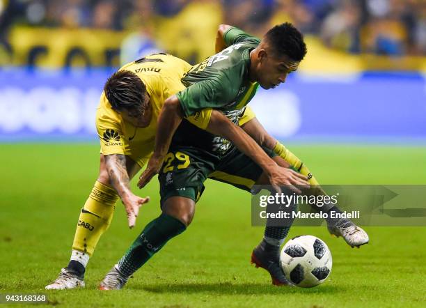 Nicolas Fernandez of Defensa y Justicia fights for the ball with Julio Buffarini of Boca Juniors during a match between Boca Juniors and Defensa y...