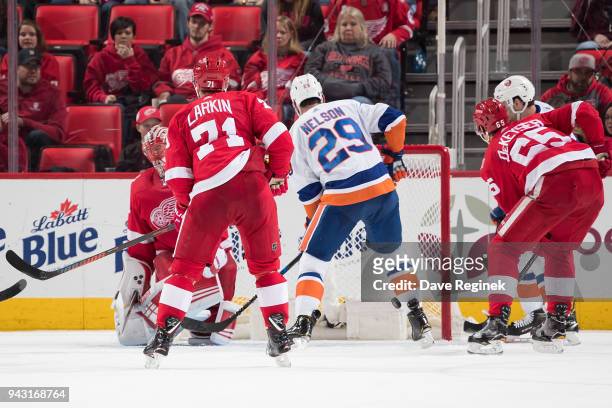 Ryan Pulock of the New York Islanders s scores a third period goal as teammate Brock Nelson looks for the rebound in front of Jared Coreau, Dylan...