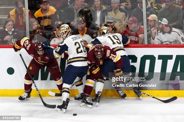 Jade Miller and Matt Anderson of the Minnesota-Duluth Bulldogs battle Jack Jenkins and Mike O'Leary of the Notre Dame Fighting Irish for the puck...