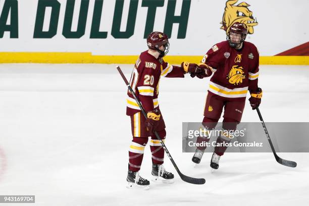 Jade Miller congratulates Karson Kuhlman of the Minnesota-Duluth Bulldogs after his goal past Cale Morris of the Notre Dame Fighting Irish during the...