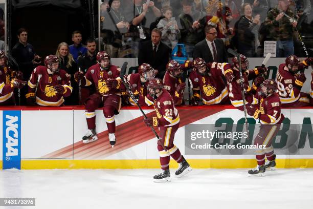 Teammates congratulate Karson Kuhlman of the Minnesota-Duluth Bulldogs after his goal past Cale Morris of the Notre Dame Fighting Irish during the...