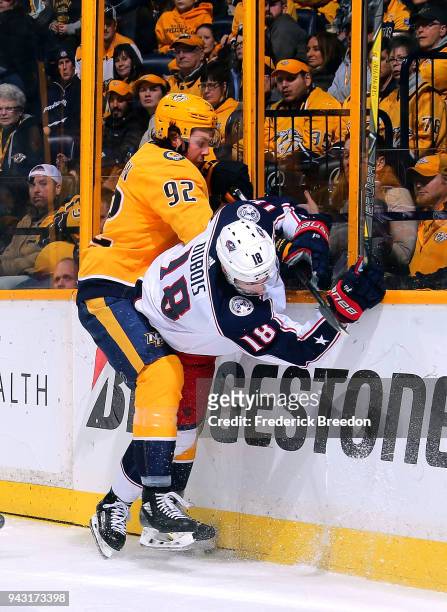Ryan Johansen of the Nashville Predators checks Pierre-Luc Dubois of the Columbus Blue Jackets into the boards during the second period at...