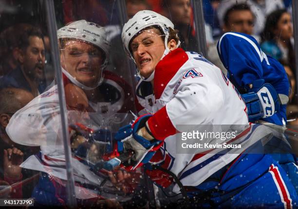 Michael McCarron of the Montreal Canadiens is checked by Jake Gardiner of the Toronto Maple Leafs during the third period at the Air Canada Centre on...