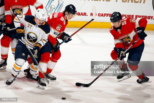 Casey Mittelstadt of the Buffalo Sabres tangles with Henrik Borgstrom and MacKenzie Weegar of the Florida Panthers at the BB&T Center on April 7,...