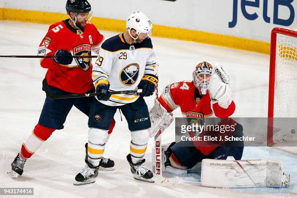 Goaltender James Reimer of the Florida Panthers defends the net with the help of teammate Aaron Ekblad against Jason Pominville of the Buffalo Sabres...