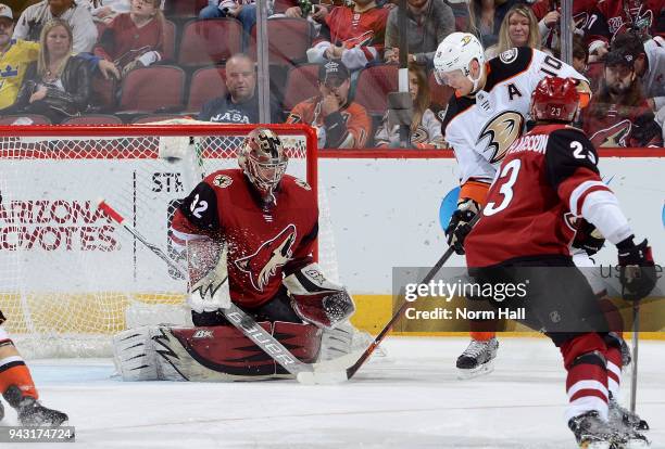 Goalie Antti Raanta of the Arizona Coyotes stops the puck in front of Corey Perry of the Anaheim Ducks during first period at Gila River Arena on...