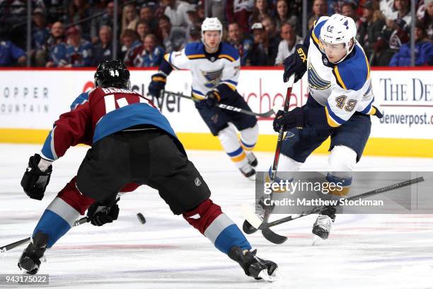 Ivan Barbashev of the St Louis Blues advances the puck against Mark Barberio of the Colorado Avalanche at the Pepsi Center on April 7, 2018 in...