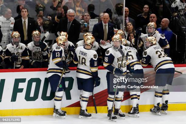 The Notre Dame Fighting Irish gather for a timeout against the Minnesota-Duluth Bulldogs during the Division I Men's Ice Hockey Semifinals held at...