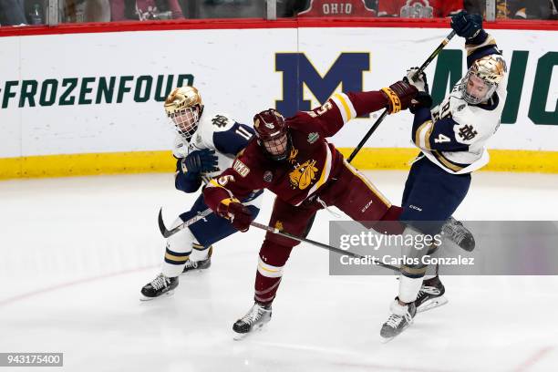 Nick Wolff of the Minnesota-Duluth Bulldogs battles with Cal Burke and Dennis Gilbert of the Notre Dame Fighting Irish during the Division I Men's...