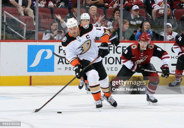 Ryan Getzlaf of the Anaheim Ducks advances the puck up ice ahead of Clayton Keller of the Arizona Coyotes during first period at Gila River Arena on...