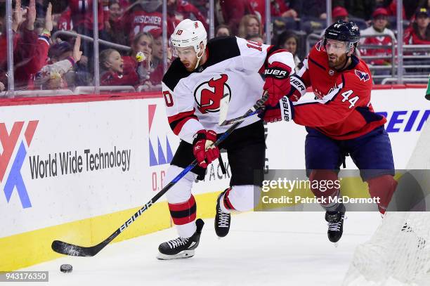 Jimmy Hayes of the New Jersey Devils and Brooks Orpik of the Washington Capitals battle for the puck in the third period at Capital One Arena on...
