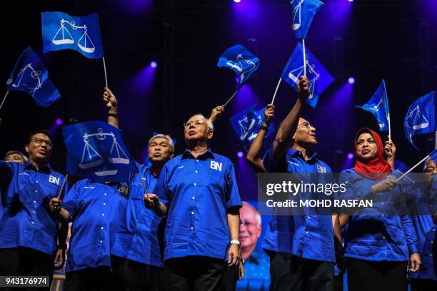 This picture taken on April 7, 2018 shows Malaysian Prime Minister Najib Razak waving his party's flag with other members party before launching his...