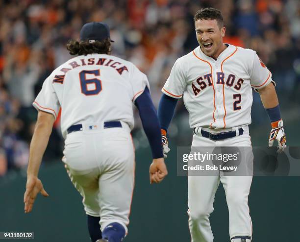 Alex Bregman of the Houston Astros celebrates with Jake Marisnick after his walk-off pop fly single in the tenth inning to beat the San Diego Padres...