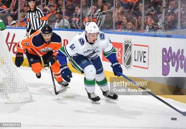 Ty Rattie of the Edmonton Oilers battles for the puck against Troy Stecher of the Vancouver Canucks on April 7, 2018 at Rogers Place in Edmonton,...