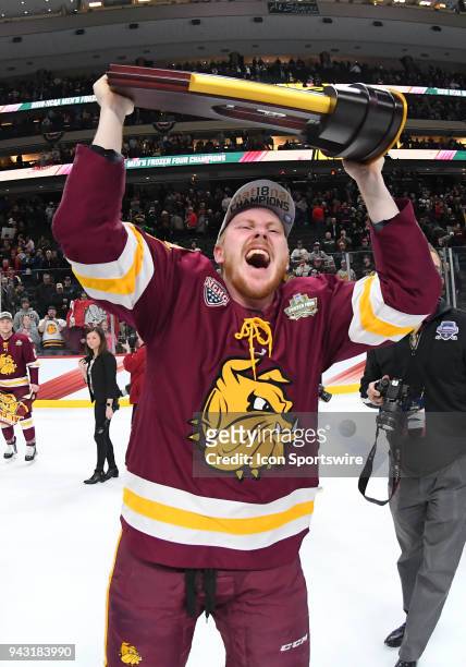 Minnesota-Duluth Bulldogs defenseman Nick McCormack skates with the national title trophy after the Frozen Four Final between the University of...