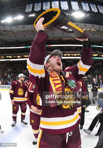 Minnesota-Duluth Bulldogs forward Joey Anderson skates with the national title trophy after the Frozen Four Final between the University of...