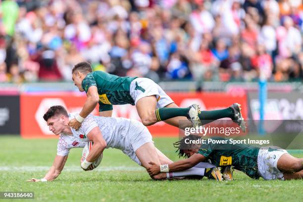 Stedman Gans and Muller du Plessis of South Africa put a tackle of Ben Howard of England during the HSBC Hong Kong Sevens 2018 match between South...